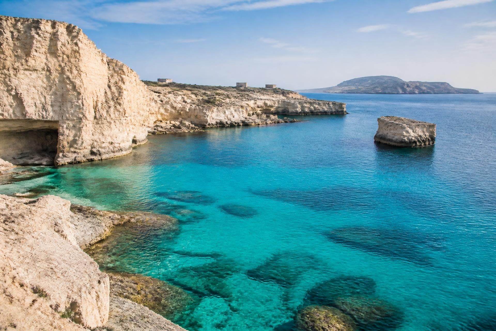Cala di tufo bianco a Favignana con mare turchese e cielo azzurro